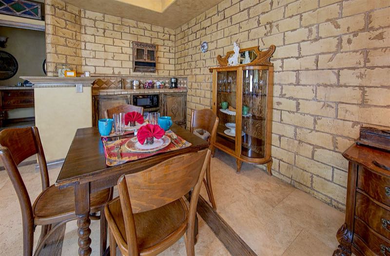 Antiquities villa kitchenette and dining table against stone walls