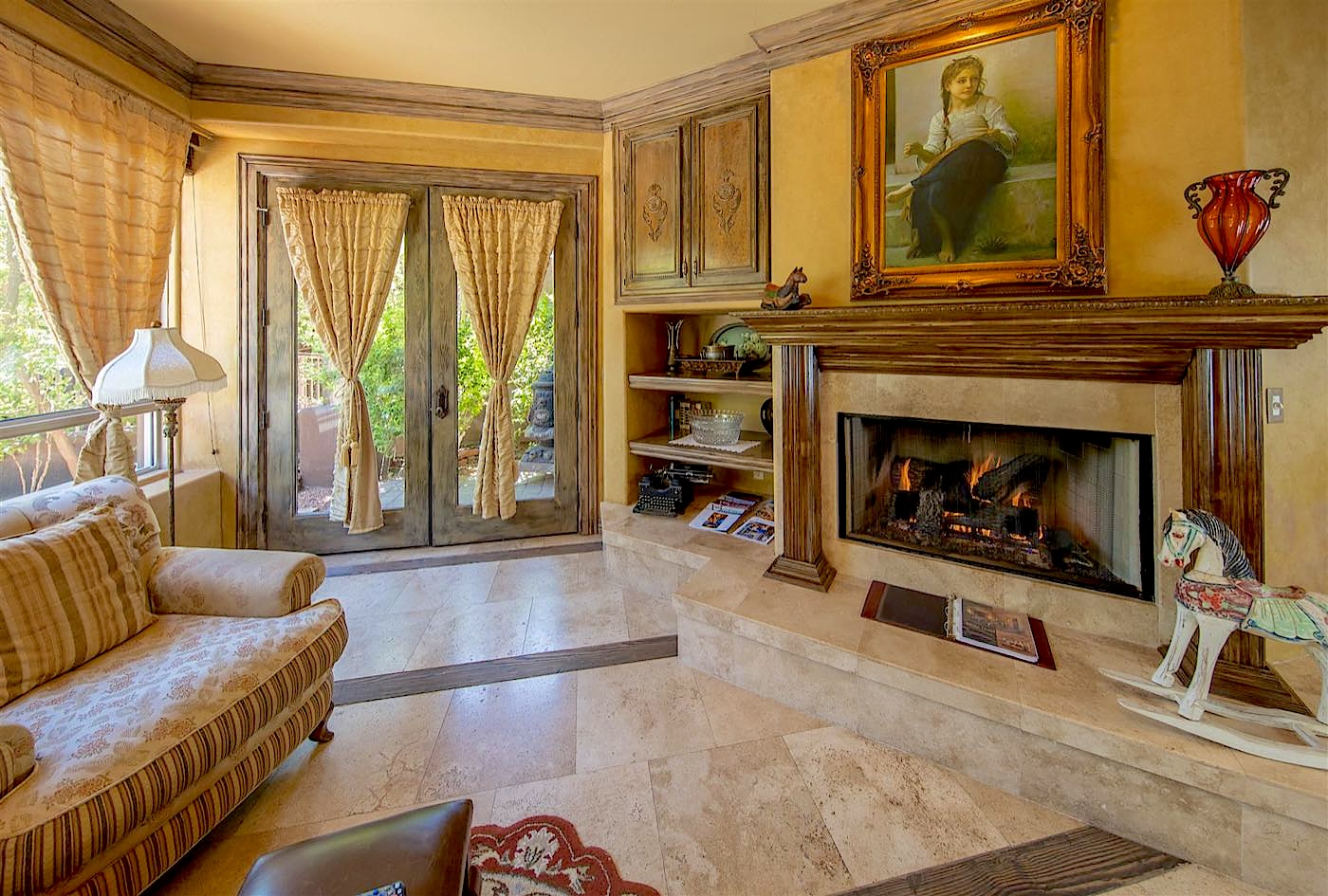 Antiquities villa sitting room with a fireplace and patio doors