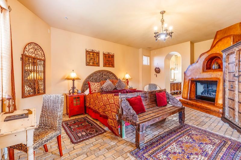 Hacienda villa bedroom with a fireplace and red bedding