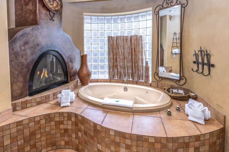 Sedona Breeze villa jetted tub beside a fireplace and glass-block window