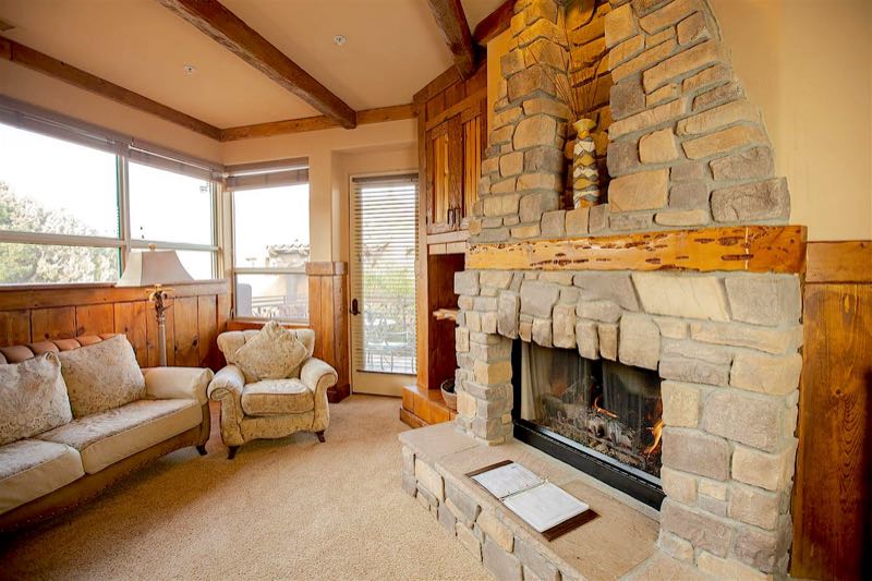 Timbers villa sitting area with a stone fireplace