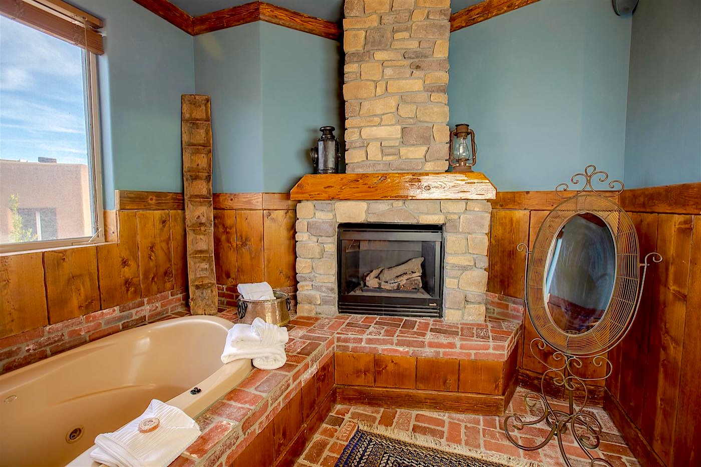 Timbers villa jetted tub beside a stone fireplace