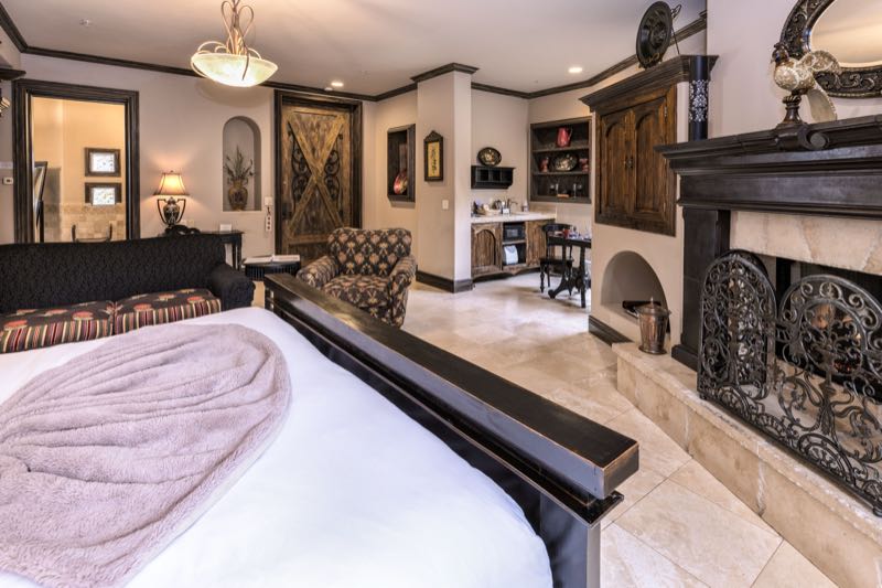 Tuscany villa bed and dark wood fireplace