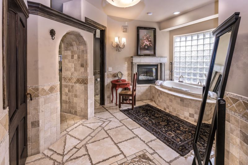 Tuscany villa bathroom with a stone walk-in shower and jetted tub