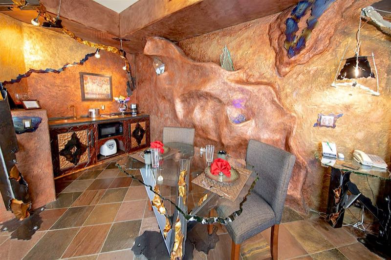 Visions villa sculpted copper walls and glass dining table