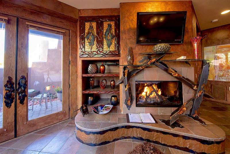 Visions villa fireplace with metal sculpture and patio doors